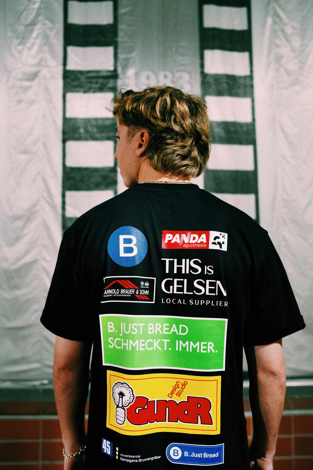 Läufer von hinten mit B. Just Bread Running Shirt und verschiedenen Markenlogos