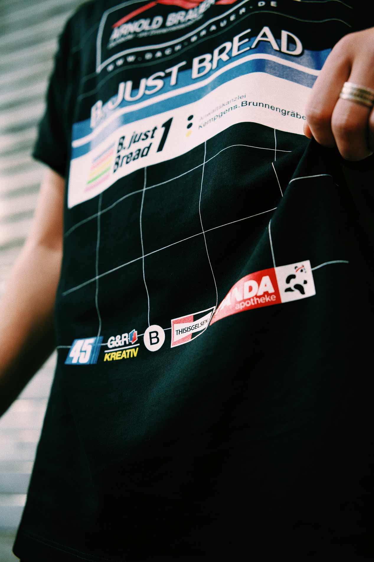 Detailaufnahme eines B. Just Bread Running Shirts mit Markenlogos und grafischem Design