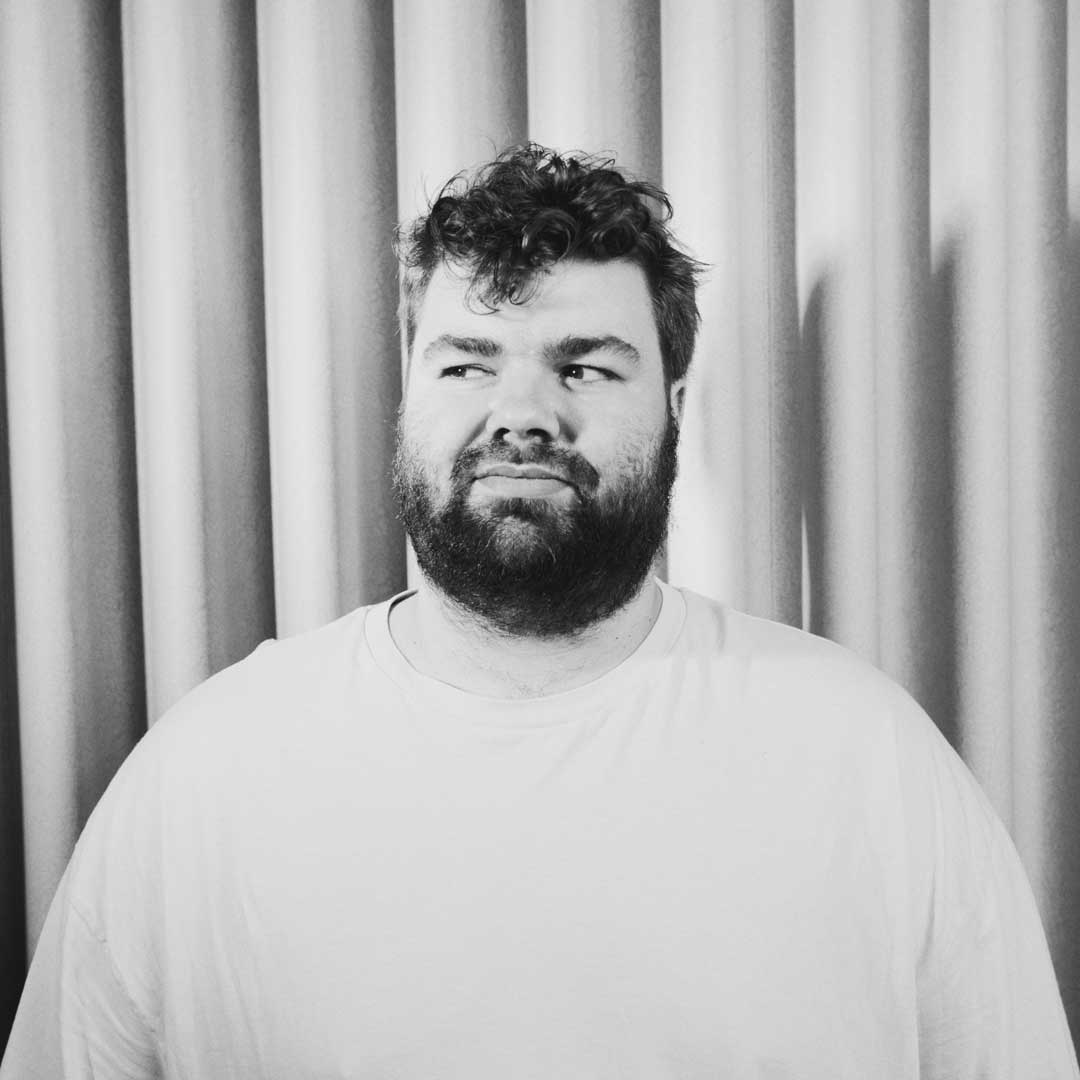 Porträt von Joey Hartmann vor einem Vorhang